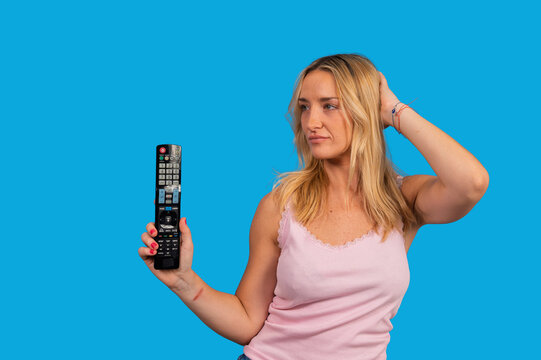 Woman holding remote control finding nothing to watch
