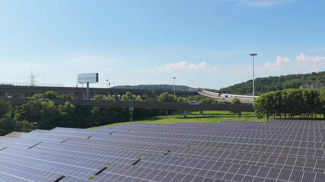 Aerial view panning from solar panels toward elevated highways