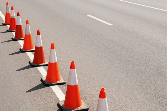 orange traffic cones lined up along asphalt road for safety and organization concept