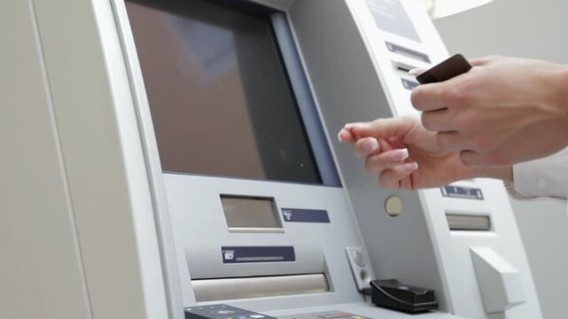 Withdrawing money from ATM machine with close up handheld shot of person taking cash and currency from automated teller in 4K Ultra HD footage
