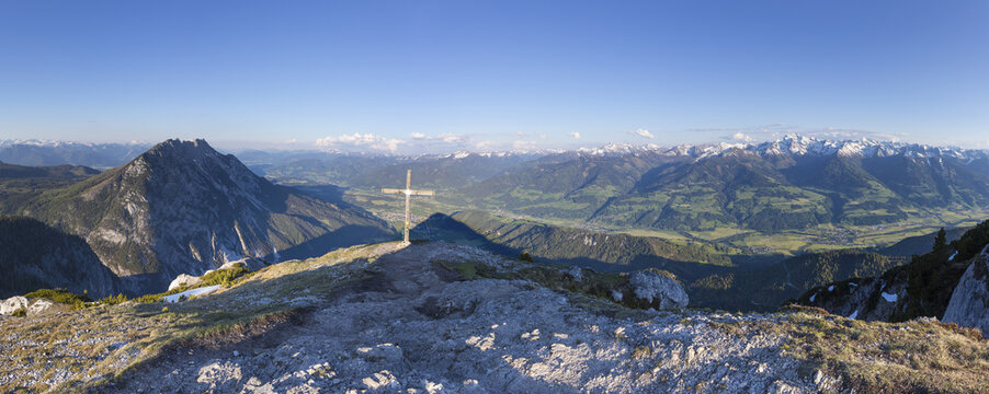 View of the summit cross on Stoderzinken overlooking the alpine Ennstal valley and surrounding mountain ranges in Grobming, Steiermark, Austria.