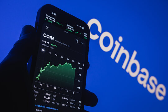 Raleigh, North Carolina - August 3rd, 2026: Hand holding smartphone displaying Coinbase stock chart and ticker with the logo in the background.