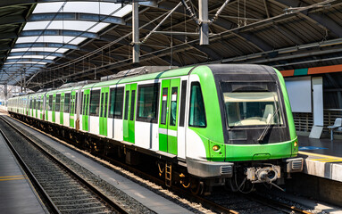 Obraz premium A green and white metro train standing at Estacion Bayovar platform in San Juan de Lurigancho, Lima, Peru