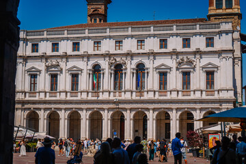 Obraz premium Historic Palazzo Nuovo in Bergamo, Italy, featuring classical architecture and vibrant crowds enjoying the sunny day