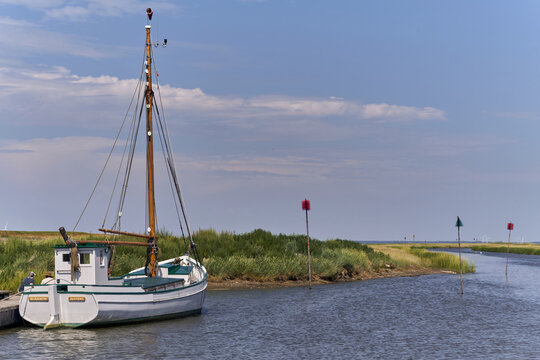 View of the historic Evert flat-bottom ship Karen of Mando moored in the small Wadden Sea harbor of Sonderho, Denmark.