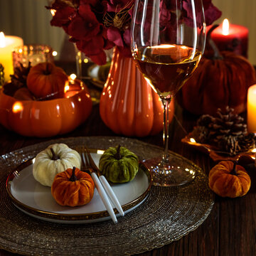 Elegant Table Setting with Velvet Pumpkins and Wine for Autumn Celebration and Thanksgiving Feast