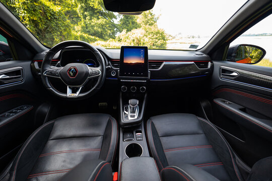 Renault Arkana RS Line cockpit presents flat bottom steering wheel, carbon fiber style dash, red stitched leather seats, aluminum pedals, and 10 50, 12 C display