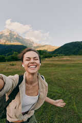 Obraz premium Woman enjoying outdoor lifestyle in a sunny mountain field, smiling during a carefree selfie, embracing nature and adventure in fresh air sun