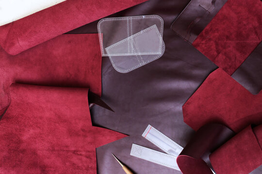 Genuine burgundy leather for manufacture of products and accessories. Tanner's tools for cutting leather. High-quality leather. Manufacture of accessories made of natural or artificial leather