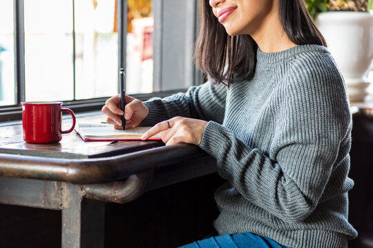 Woman writing by window light