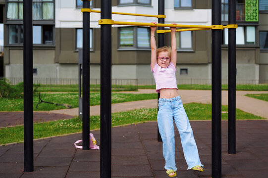 Little girl having fun on the playground monkey bars