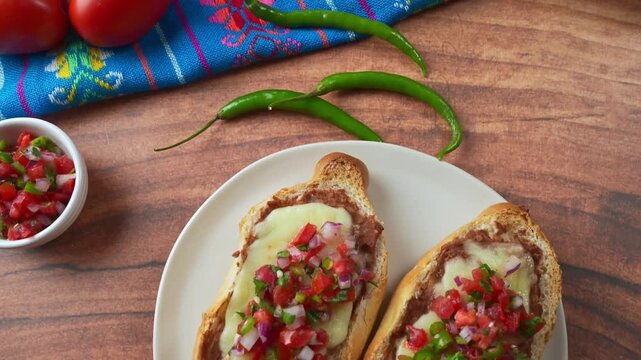 Aerial view of delicious Mexican Molletes with refried beans, melted cheese and pico de gallo topping