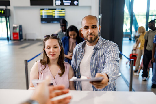 Couple checking in at the airport for their flight to a new destination