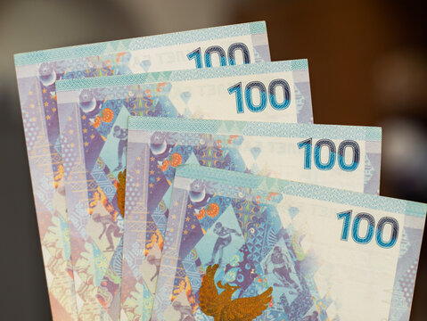 Hand Holding Russian 100 Ruble Banknotes with Colorful Design