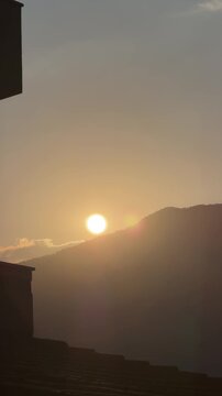 Sunset over the mountains as the day ends and shadows grow around the surrounding landscape