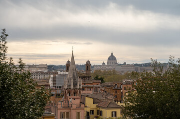 Fototapeta premium City view on roofs and churches of Rome from panoramic route near villas Borghese and Medici, walking in Rome in spring evening, soft sunset lights, guided tour