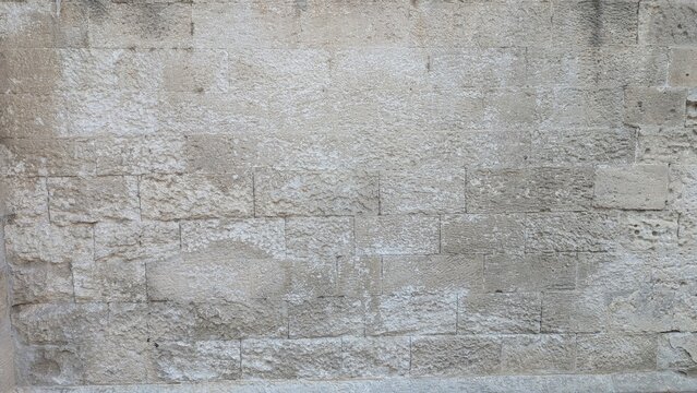Weathered limestone ashlar wall texture in warm natural light