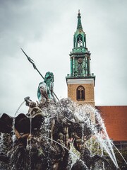 Neptunbrunnen in Berlin mit Neptun Skulptur und Turm der Marienkirche © Annika Shurafa