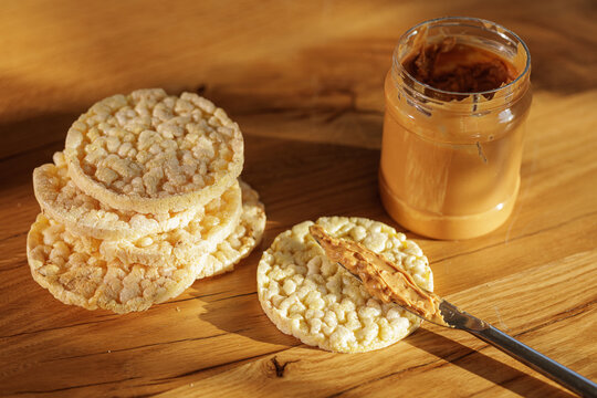 Peanut Butter Spread On Crispy Rice Cakes In Warm Light