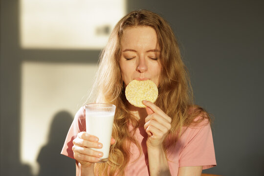 Woman Enjoying Healthy Breakfast With Milk And Corn Rice Cracker