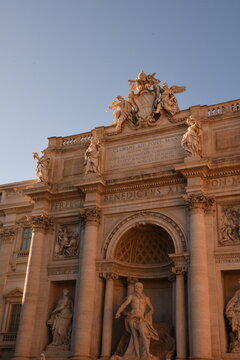 Barocke Fassade des Trevi-Brunnens mit Oceanus-Statue und Papst-Inschrift im Abendlicht in Rom, Italien