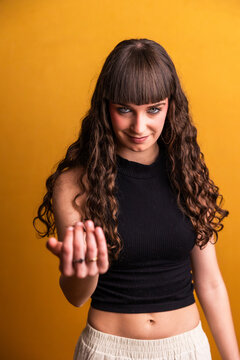 Young dancer making inviting gesture on yellow background