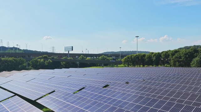 Drone rising above solar panels to reveal an elevated highway