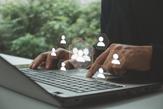 Businessman using laptop with virtual team network interface, representing digital communication, human resources, online collaboration, remote workforce, recruitment and global business connectivity.