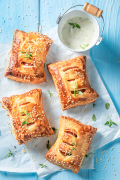Crispy sausage in puff pastry with tatar sauce and herbs.