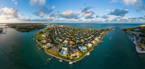 Aerial panoramic view of luxury coastal homes on a peninsula along the ocean inlet in Jupiter, Florida, USA.  December 29, 2022.  © JHorsey