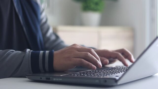 Man typing laptop keyboard, Person using computer, Businessman working with laptop on white table at home office.  Online communication, remote work, customer service, IT support, Business technology.