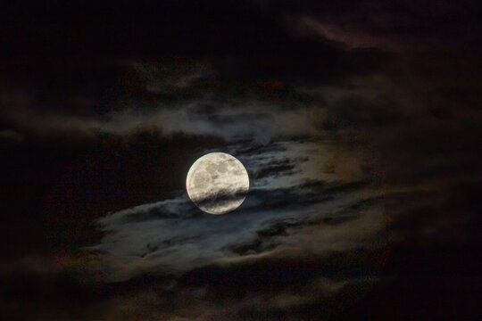 Full moon in the night sky with clouds