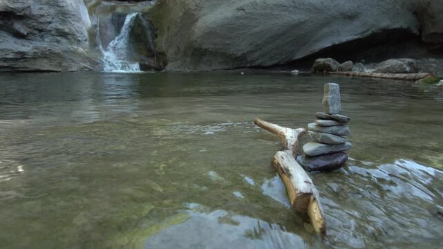 Zen Steine Stapel im fliessend Gew&auml;sser mit Wasserfall im Hintergrund - Natur und Entspannung