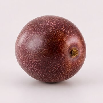 Whole passion fruit isolated on a white background, showcasing its vibrant speckled skin and unique texture