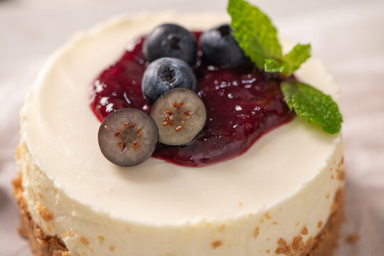 Mini cheesecake with blueberry topping and mint leaves macro view