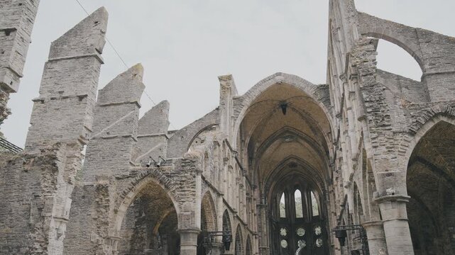 Majestic gothic arches and towering stone walls of the ruined medieval Villers Abbey church in Belgium.