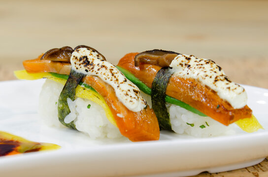 Aburi salmon nigiri sushi with melted cheese and mushroom on white plate