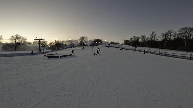 Snowboarder performing a trick jump during sunset at a snow park in Minnesota
Dynamic action shot of a snowboarder doing a high-flying trick jump against a glowing golden sunset background in a winter