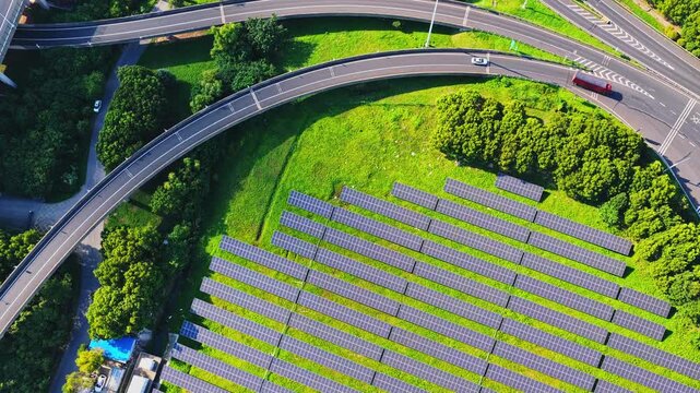 Top down drone view of solar panels framed by a road interchange