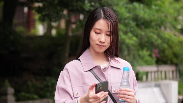 東京のレトロな観光地（深大寺近くの公道）でスマートフォンを見る女性
