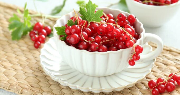 Woman taking fresh ripe red currants at table, closeup