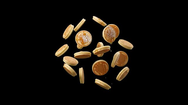 A collection of fluffy golden pancakes or round cookies floating and tumbling dynamically against a solid black backdrop. Great for breakfast commercials, bakery promos, and food advertising overlays.