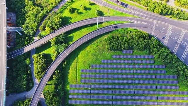 Drone ascending above a solar farm and multilane road interchange