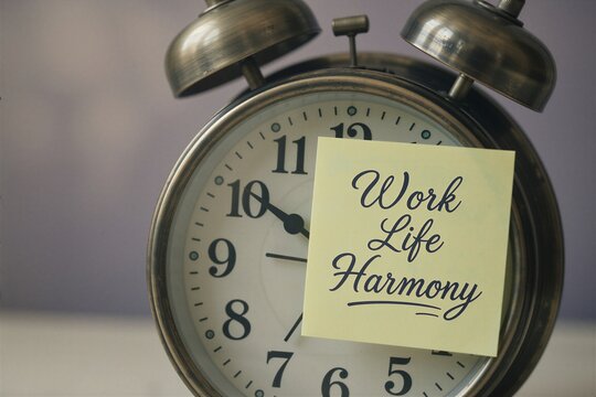 Vintage alarm clock with a Work Life Harmony note symbolizing mental health and work-life balance.