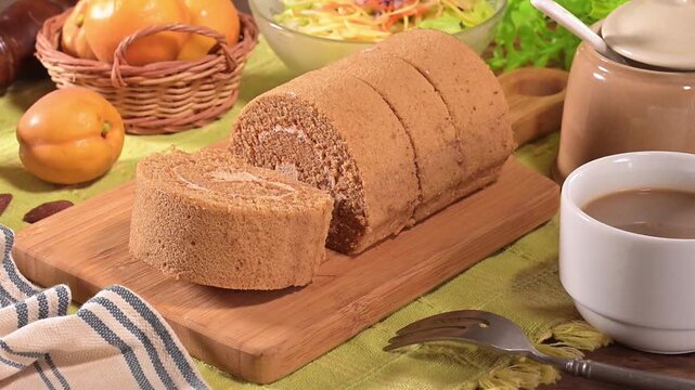 Coffee flavored swiss roll on the wooden cutting board  