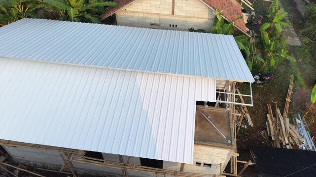 Aerial View of Residential Rooftops with Metal Sheets and Tropical Plants