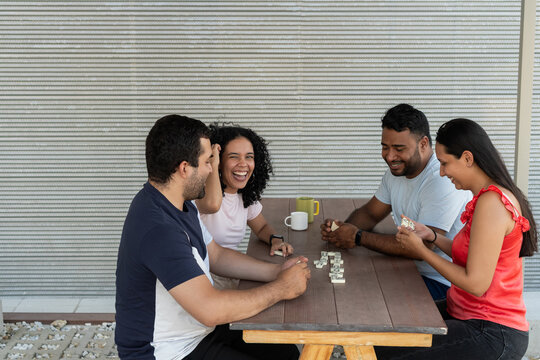 Young adult friends enjoying board game dominoes outdoors