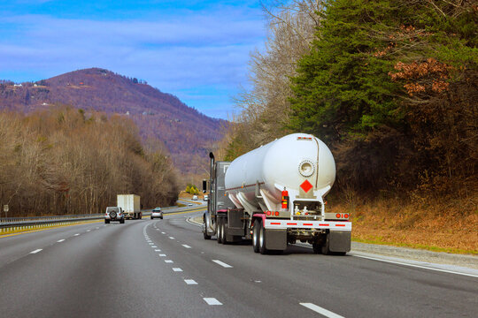 Tanker truck travels on American highway cargo transport vehicle driving an interstate road in United States