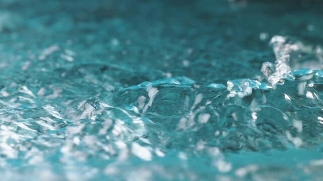 water drop splash on blue background. splashing water with transparent droplets, waves. Fresh, clean, pure liquid, cool beverage. Abstract blue background, macro shot. Nature, healthy drink. Beauty.