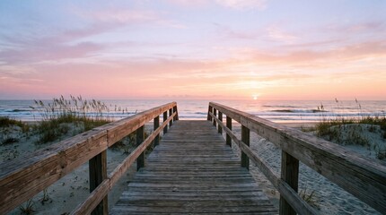 Fototapeta premium Wooden boardwalk leading to ocean beach at sunset